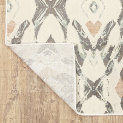 Ivory area rug with gray, sage and tan ikat pattern; folded corner shows light backing on wood floor.