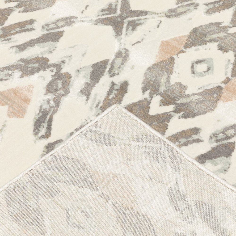 Ivory, pink, and sage geometric-pattern area rug with a stitched corner edge.