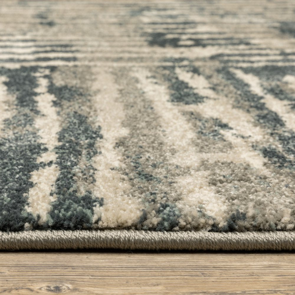 Close-up of a blue-gray and cream shag area rug edge on a wooden floor.