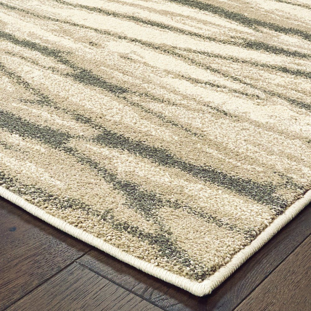Rectangular ivory, sand and ash abstract power-loom area rug with diagonal stripes on dark wood floor.