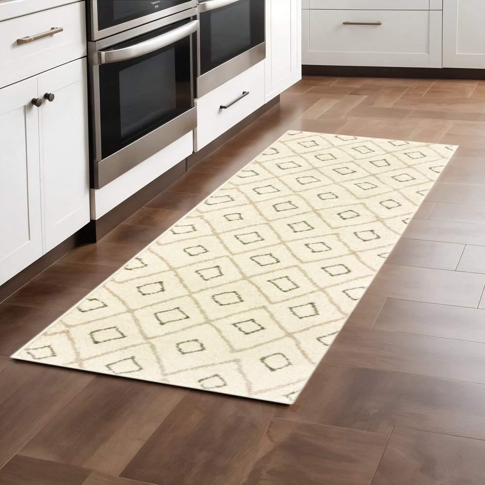 Cream runner rug with beige geometric diamond pattern on brown hardwood kitchen floor.