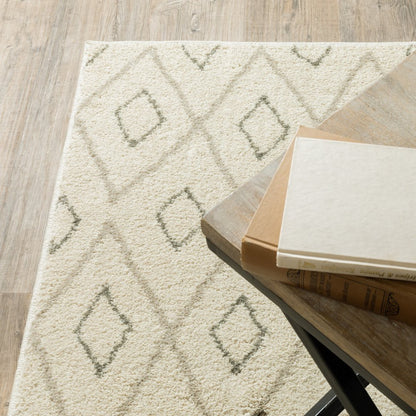 Cream area rug with subtle gray diamond pattern on light wood floor beside a wooden coffee table with a stack of magazines.