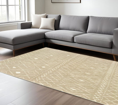 Beige geometric area rug in a bright living room with a gray L-shaped fabric sofa and wooden legs.