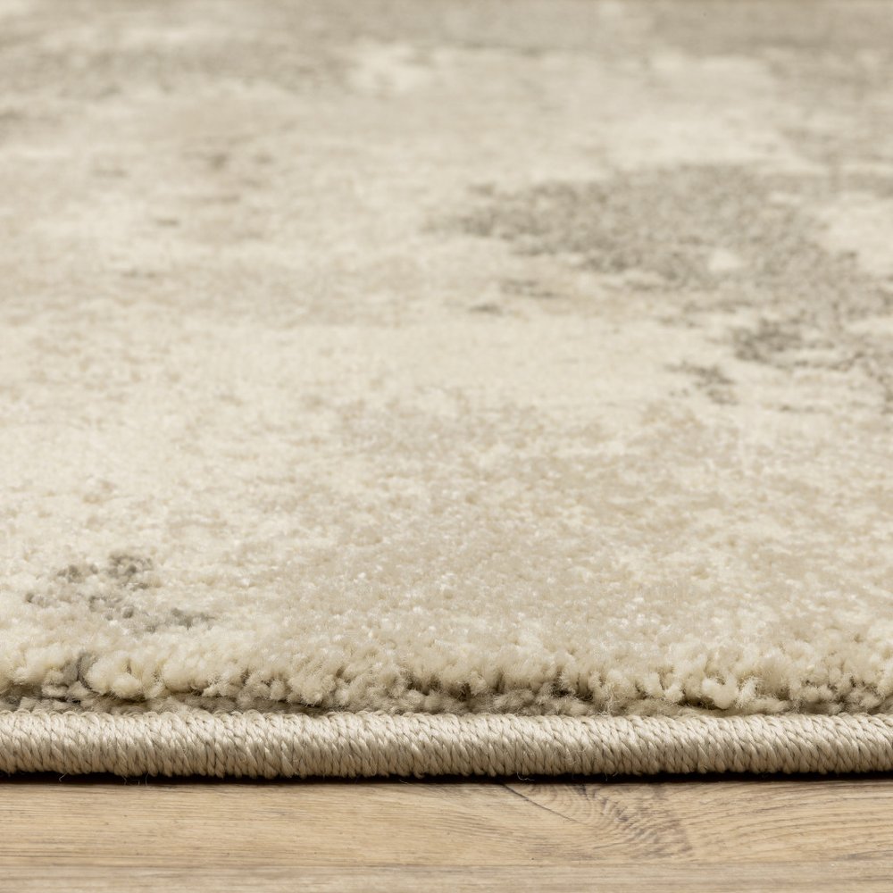 Beige and gray abstract area rug with a subtle pattern on a wooden floor.