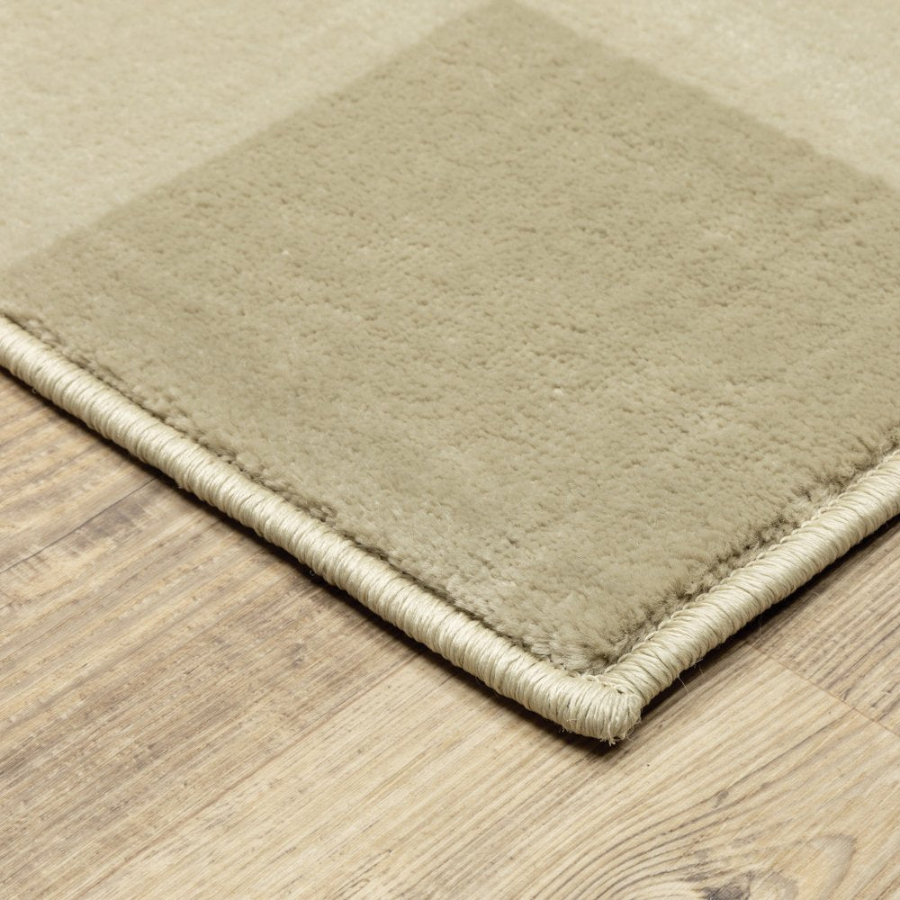 Beige and ivory geometric area rug (7' x 9') with woven bound edge on wooden floor; close-up corner.