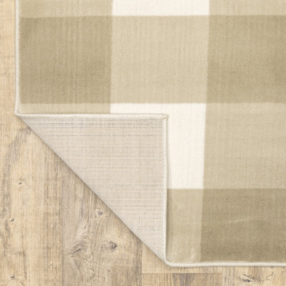 Beige and ivory geometric distressed area rug with a folded corner showing the underside on a light wood floor.