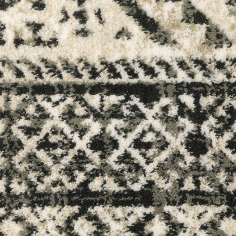 Close-up of a black and ivory shag rug with diamond geometric pattern and plush pile.