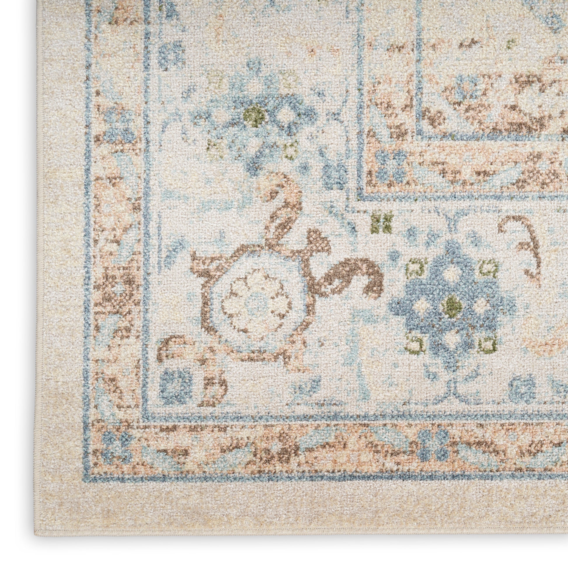 Beige oriental rug corner with blue floral border and cream-tan distressed pattern.