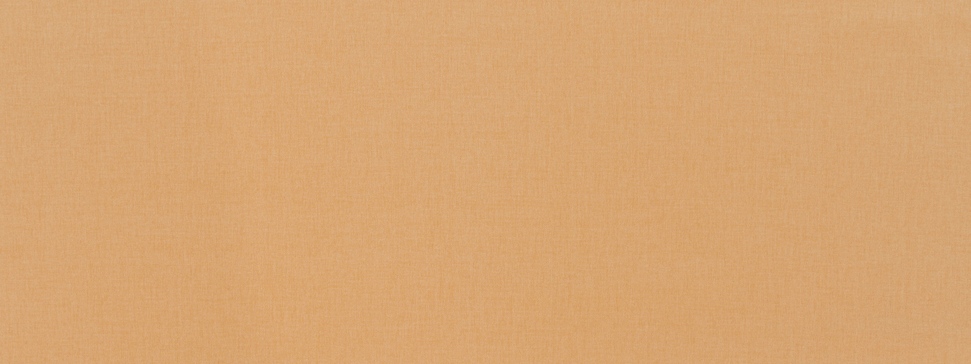 Close-up of warm peach fabric with a fine woven texture and soft beige-orange tones.