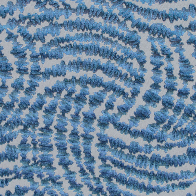 Blue and white spiral tie-dye textile pattern with jagged edges and concentric, swirling rings.
