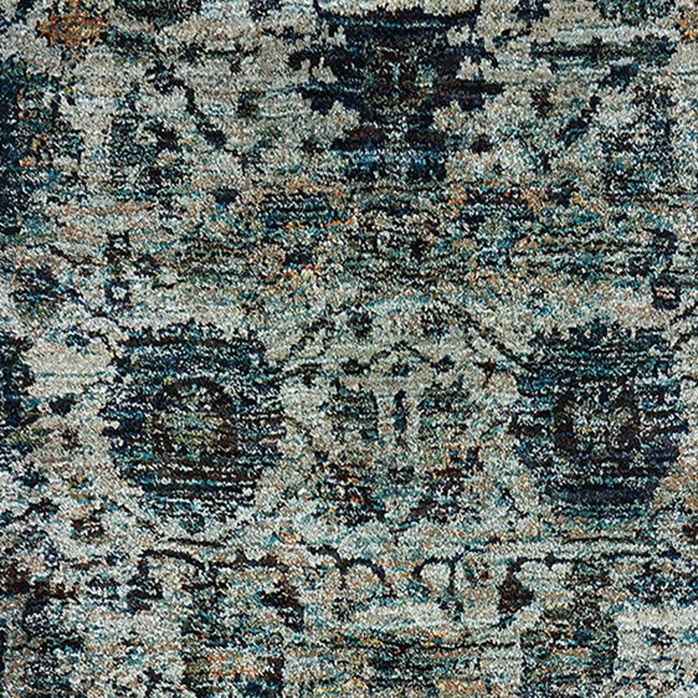 Distressed vintage oriental rug in blue, teal, ivory and gray with a floral medallion pattern.