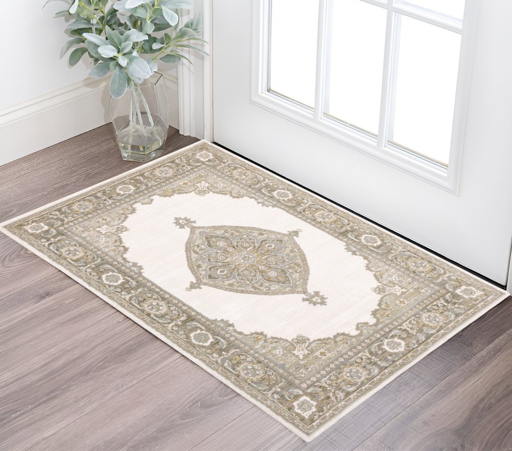 Beige oriental area rug with ornate border and central medallion, placed by a glass vase near the entry door.