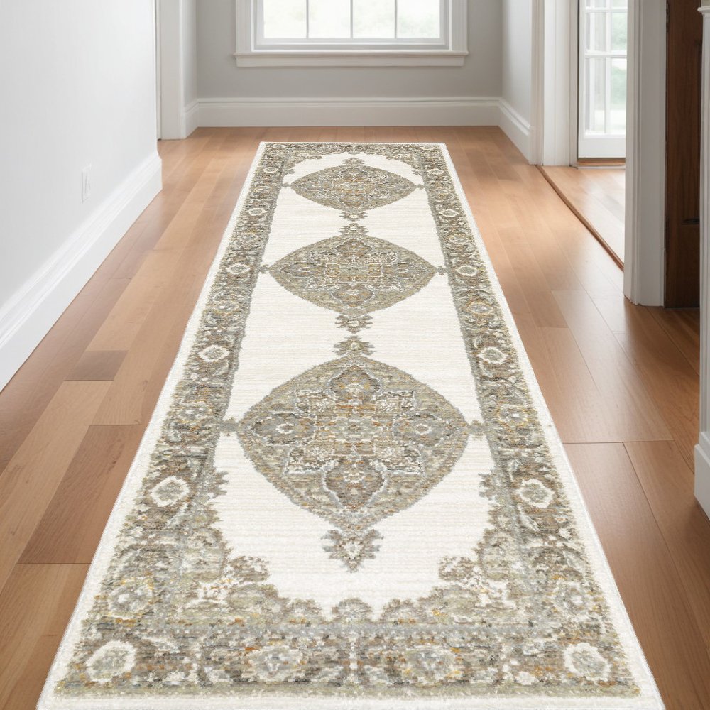Neutral-toned oriental runner rug with gold and gray medallions and decorative border in a hallway on wood floors
