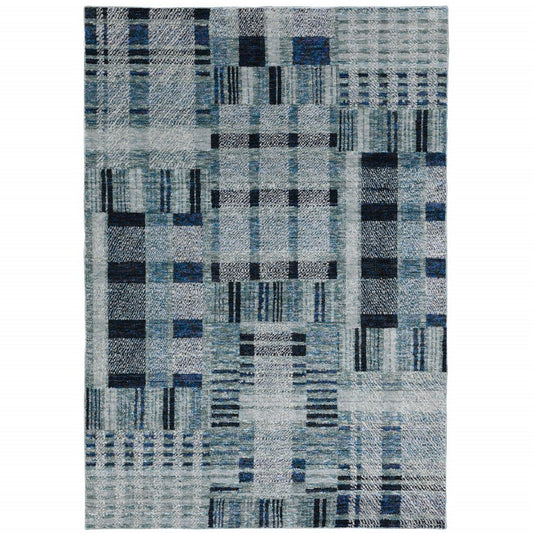 Blue-gray patchwork area rug featuring geometric rectangle blocks and lines.