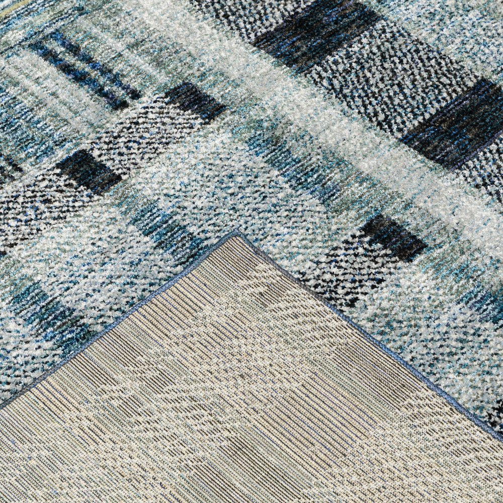 7' x 10' blue geometric power loom area rug with a textured, chunky weave; beige underside visible at a folded corner.
