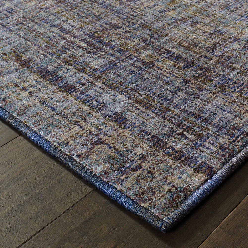 Abstract area rug in blue and ivory with a blue edge and a textured low-pile feel.