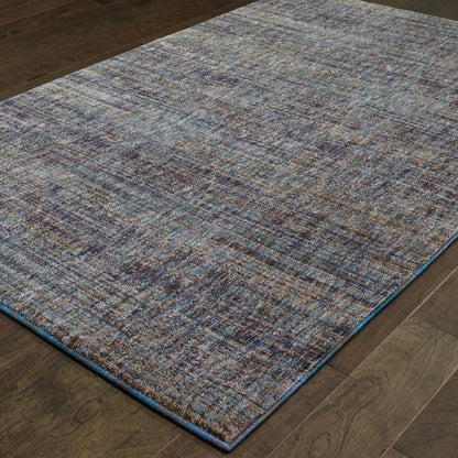 Rectangular blue and ivory abstract woven rug with blue edge and brown flecks on dark hardwood floor.