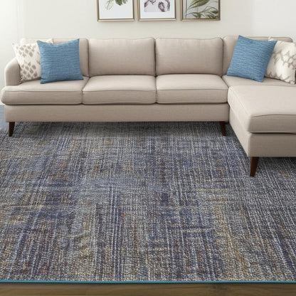 Beige fabric L-shaped sectional sofa with chaise on the right, blue accent pillows, and a blue-gray textured rug.