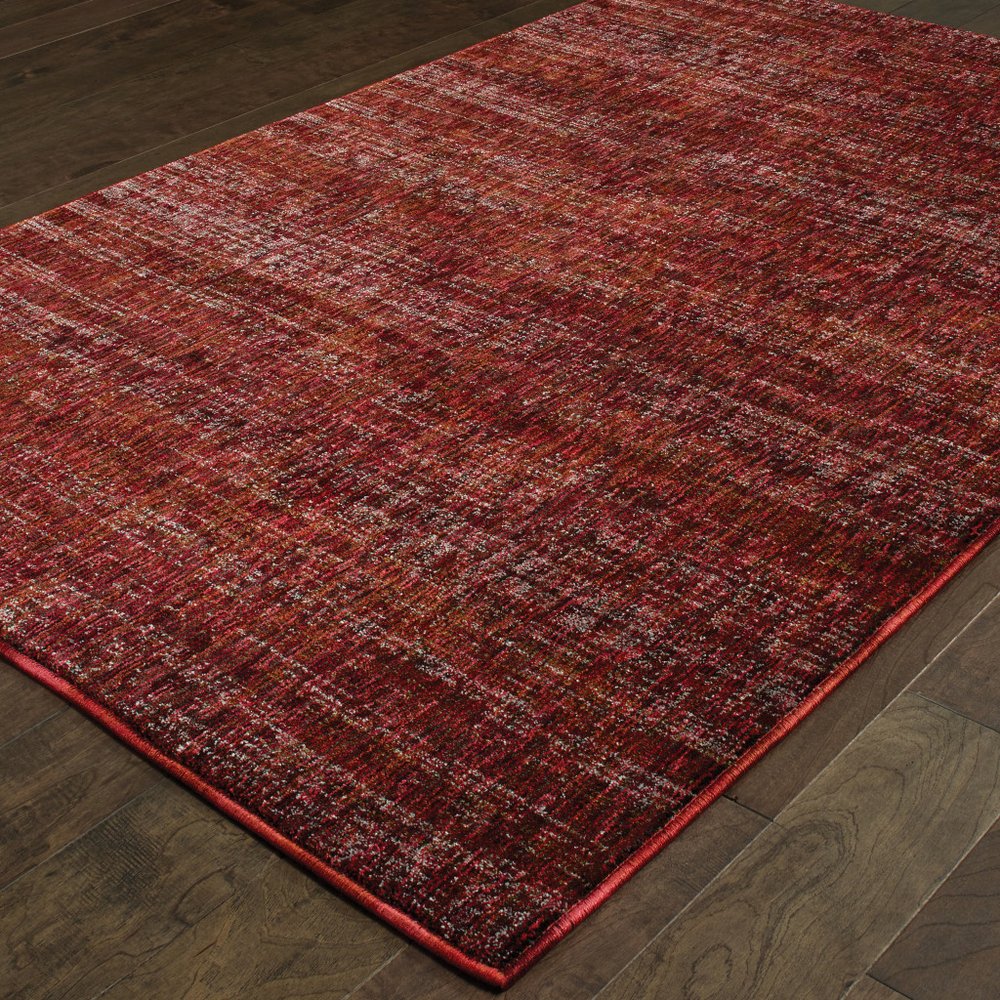Red-toned distressed area rug with burgundy and rust hues on dark wood floor.