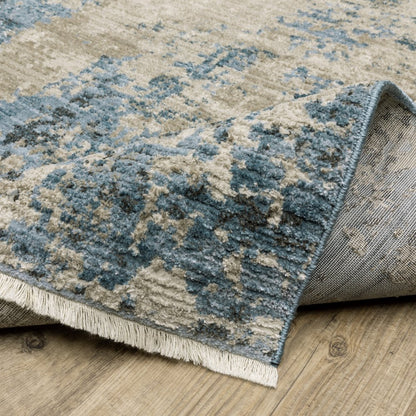 2' X 8' runner rug with a blue grey ivory light blue and dark blue abstract pattern; power loom, stain resistant, with fringe.
