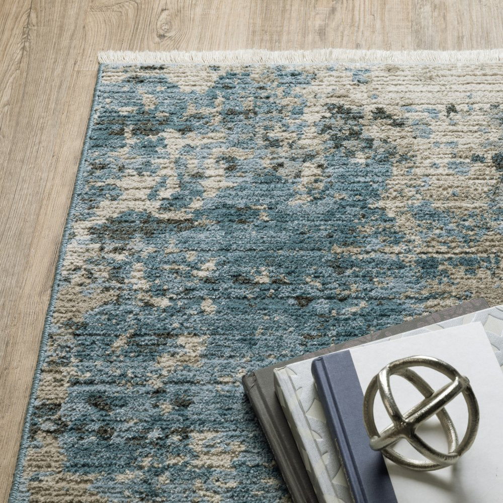 6' x 9' blue-grey ivory and light blue and dark blue abstract power-loom area rug with fringe, stain resistant.