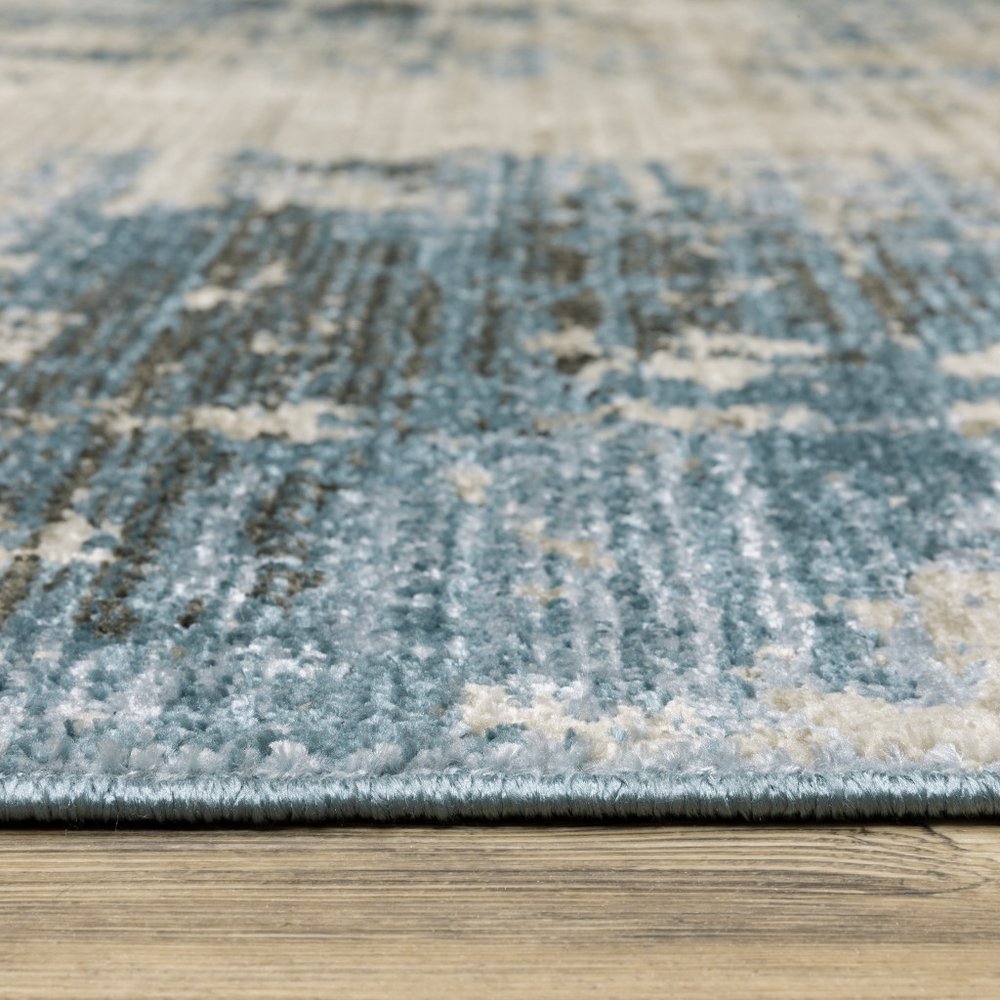 6' X 9' blue grey ivory light blue and dark blue abstract power loom stain resistant area rug with fringe