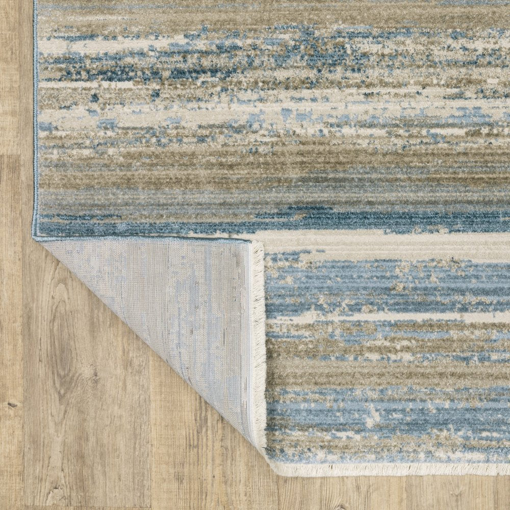 4' X 6' Ivory Beige Grey Blue And Tan Abstract Power Loom Stain Resistant Area Rug With Fringe