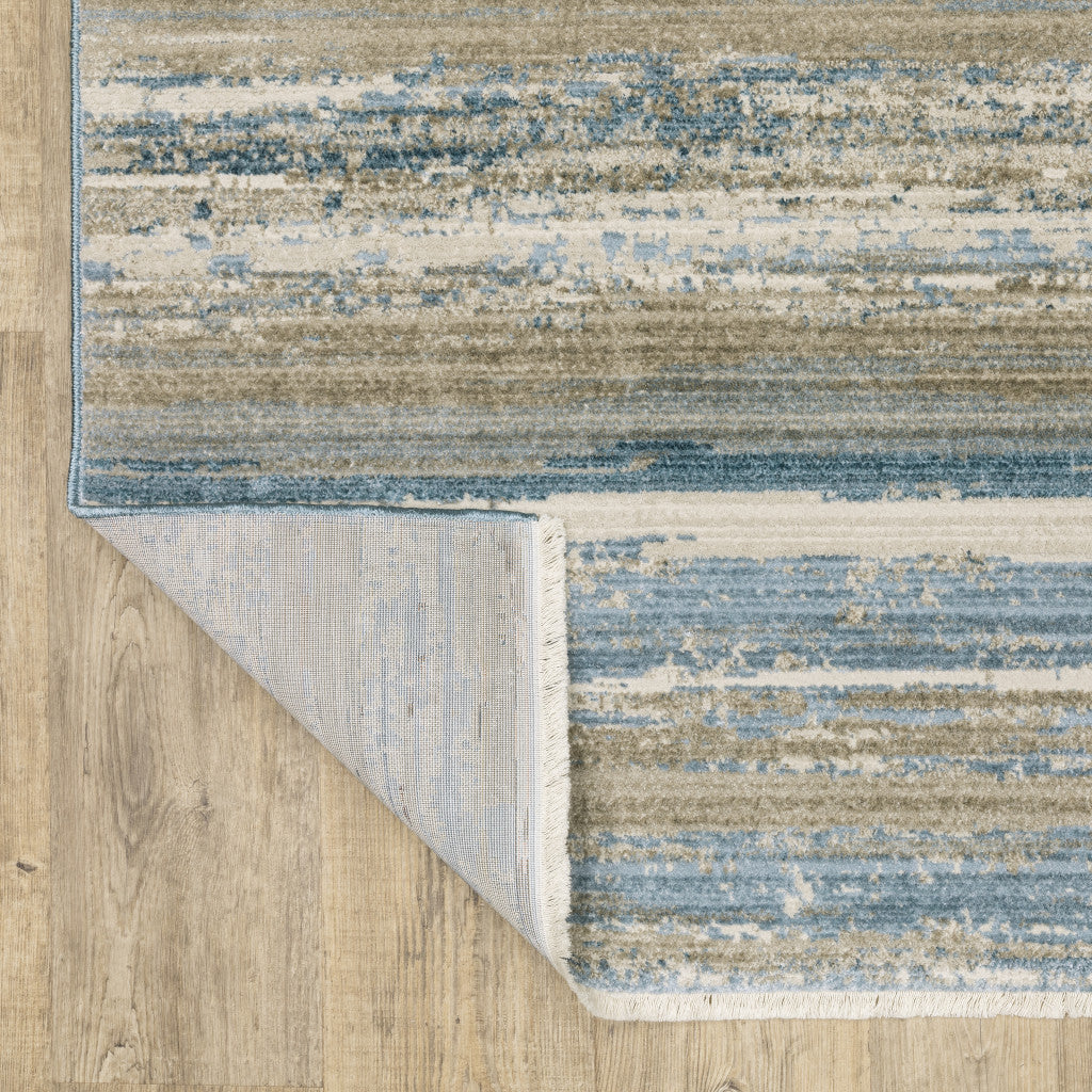 5' X 8' Ivory Beige Grey Blue And Tan Abstract Power Loom Stain Resistant Area Rug With Fringe