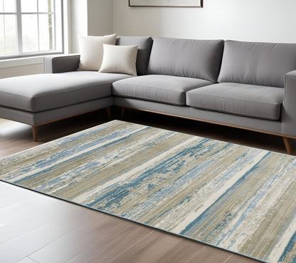 8' X 11' Ivory Beige Grey Blue And Tan Abstract Power Loom Stain Resistant Area Rug With Fringe