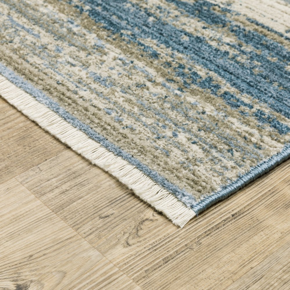 10' X 13' Ivory Beige Grey Blue And Tan abstract Power Loom stain resistant area rug with fringe