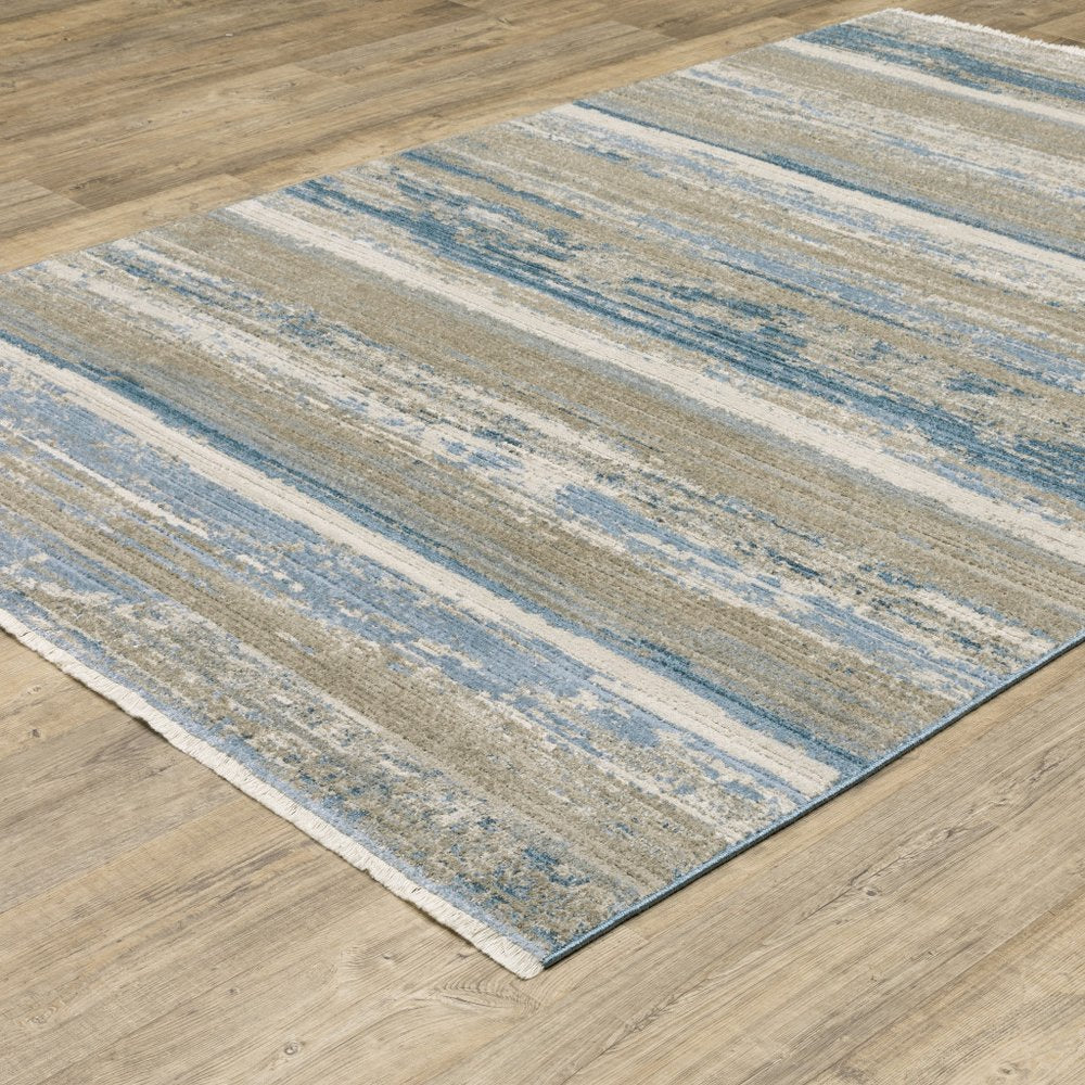 10' x 13' abstract power loom area rug in ivory, beige, gray, blue and tan with fringe; stain resistant