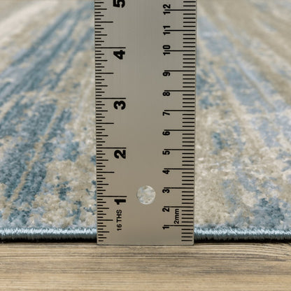 10' x 13' abstract power-loom area rug in ivory, beige, grey, blue and tan with fringe; stain-resistant.