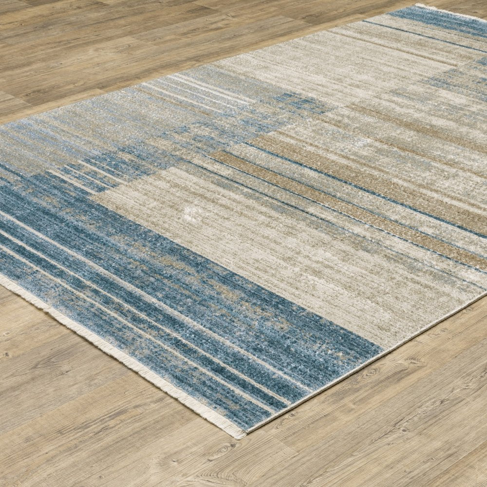 4' X 6' blue, dark blue, teal, grey, ivory, beige, and tan geometric power loom stain resistant area rug with fringe