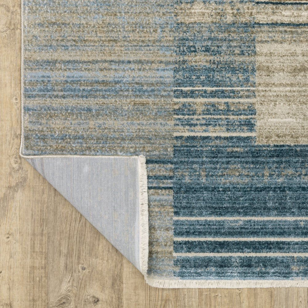 5' X 8' blue, dark blue, teal, grey, ivory, beige and tan geometric power loom area rug with fringe; stain resistant