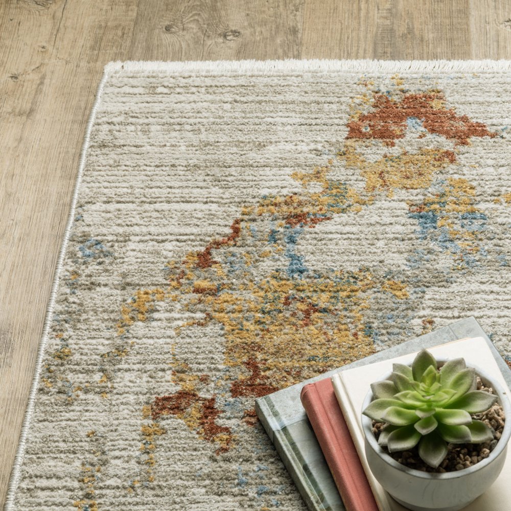 8' runner rug with fringe; abstract pattern in beige, grey, gold, blue, rust and teal.