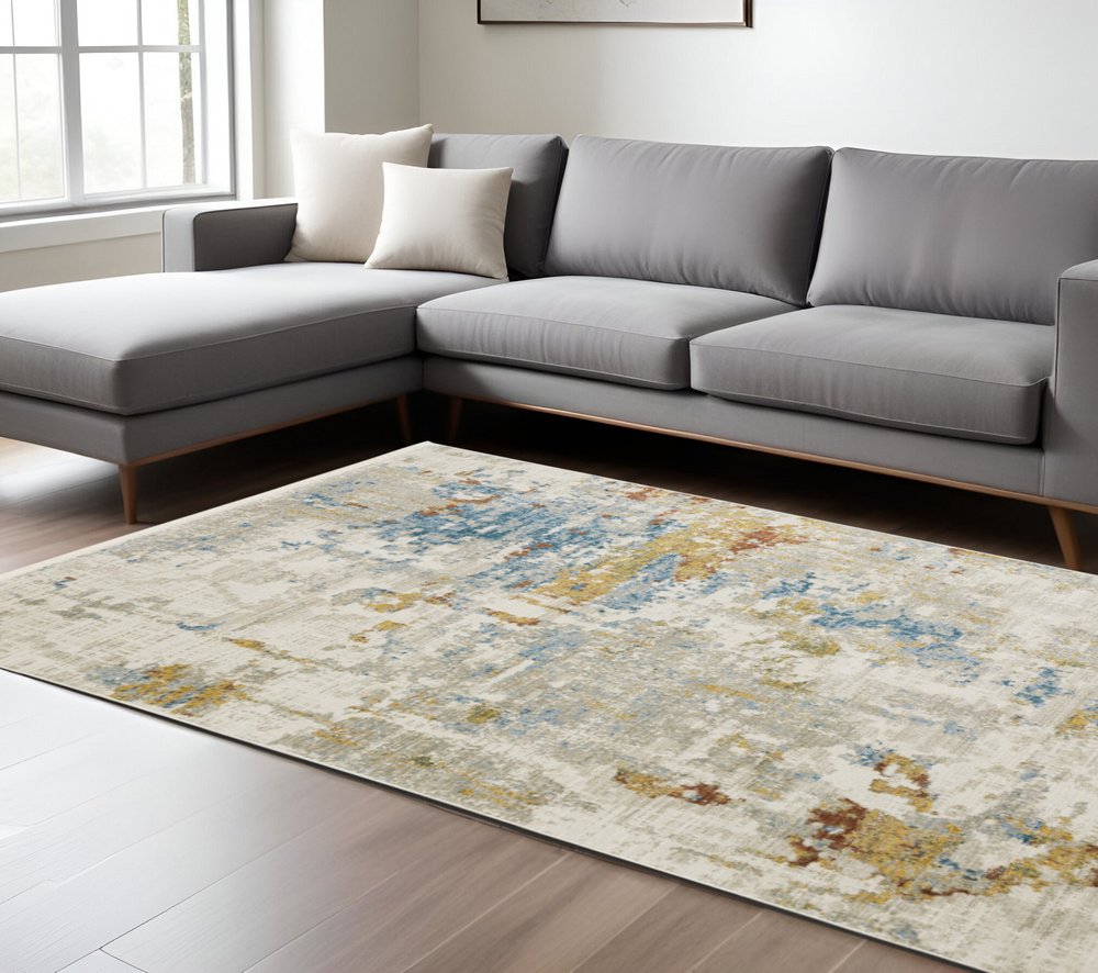 6' x 9' abstract power loom area rug with fringe in beige, grey, gold, blue, rust and teal; stain resistant.