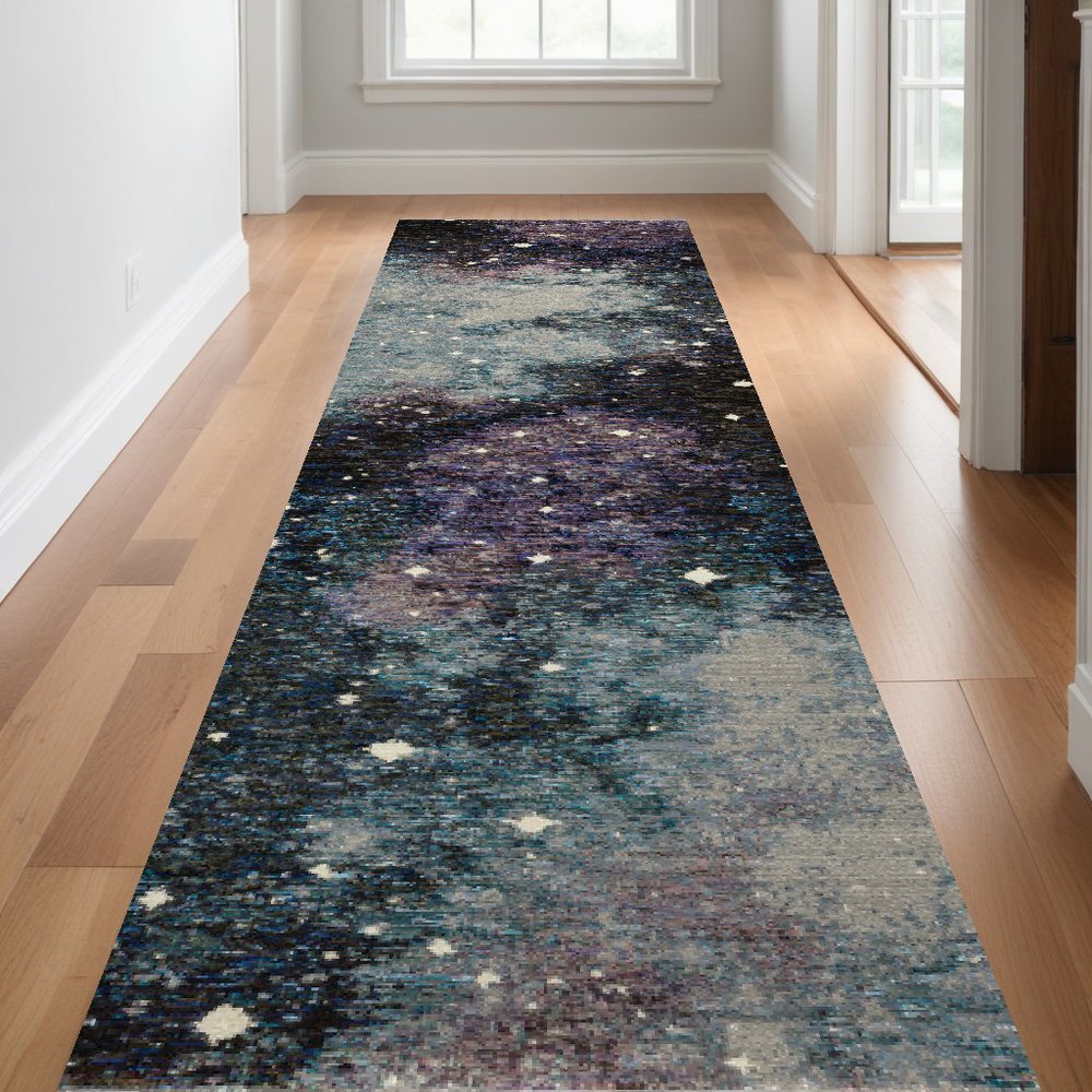 Galaxy-inspired narrow runner rug in blues & teals & purples with white star specks on a wooden hallway floor.