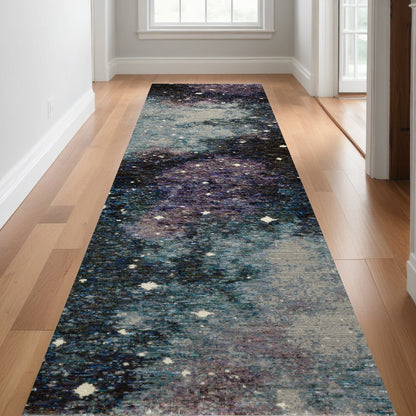 Galaxy-inspired narrow runner rug in blues & teals & purples with white star specks on a wooden hallway floor.