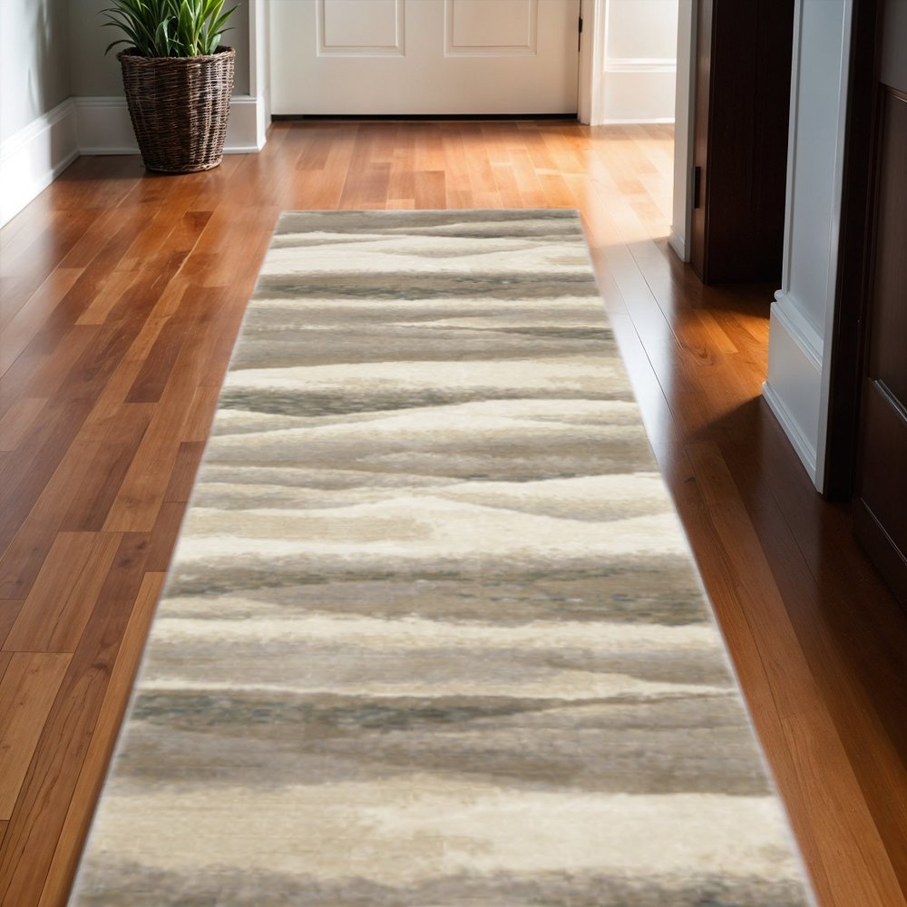 Long hallway runner rug with gray, blue and teal abstract wavy stripes on warm hardwood floor.