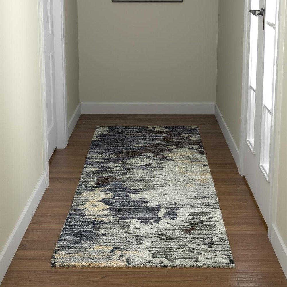 Long hallway runner rug with an abstract pattern in blue tones (navy, gray, beige and cream).