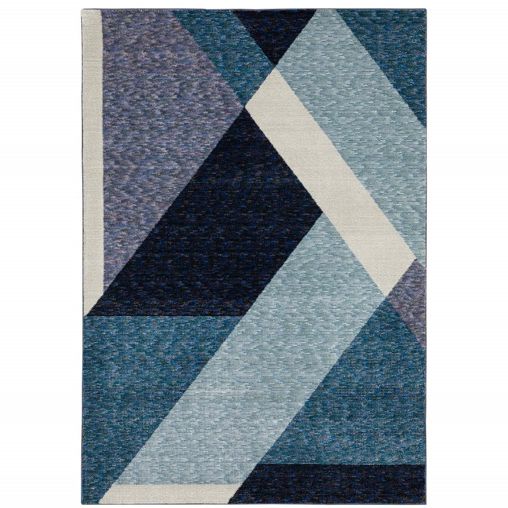 Geometric woven rug with overlapping navy, teal, light blue triangles and cream diagonal stripe.
