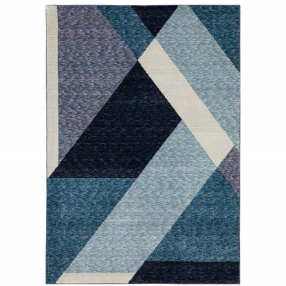 Geometric woven rug with overlapping navy, teal, light blue triangles and cream diagonal stripe.