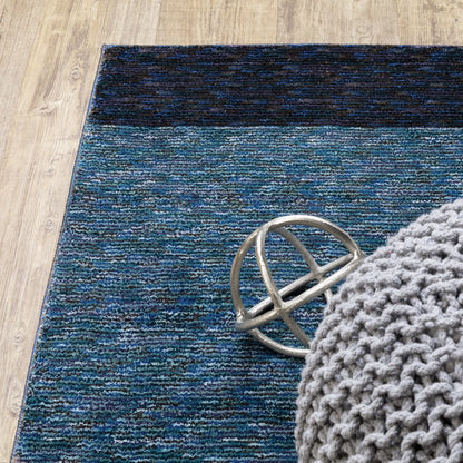 Blue gradient woven rug on wood floor with a chunky gray knit pouf and a silver circular metal accent.