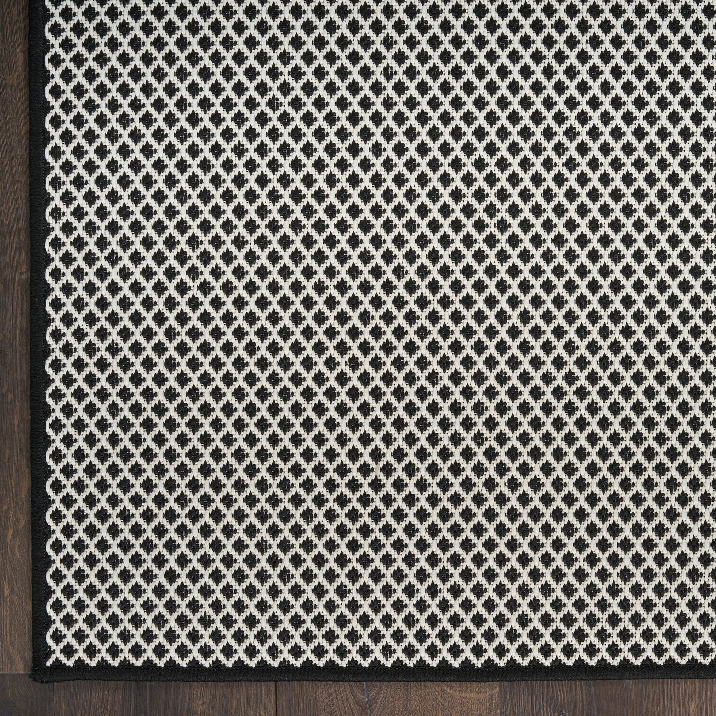 Black-framed decorative lattice panel featuring a white diamond mesh pattern on a dark textured background.