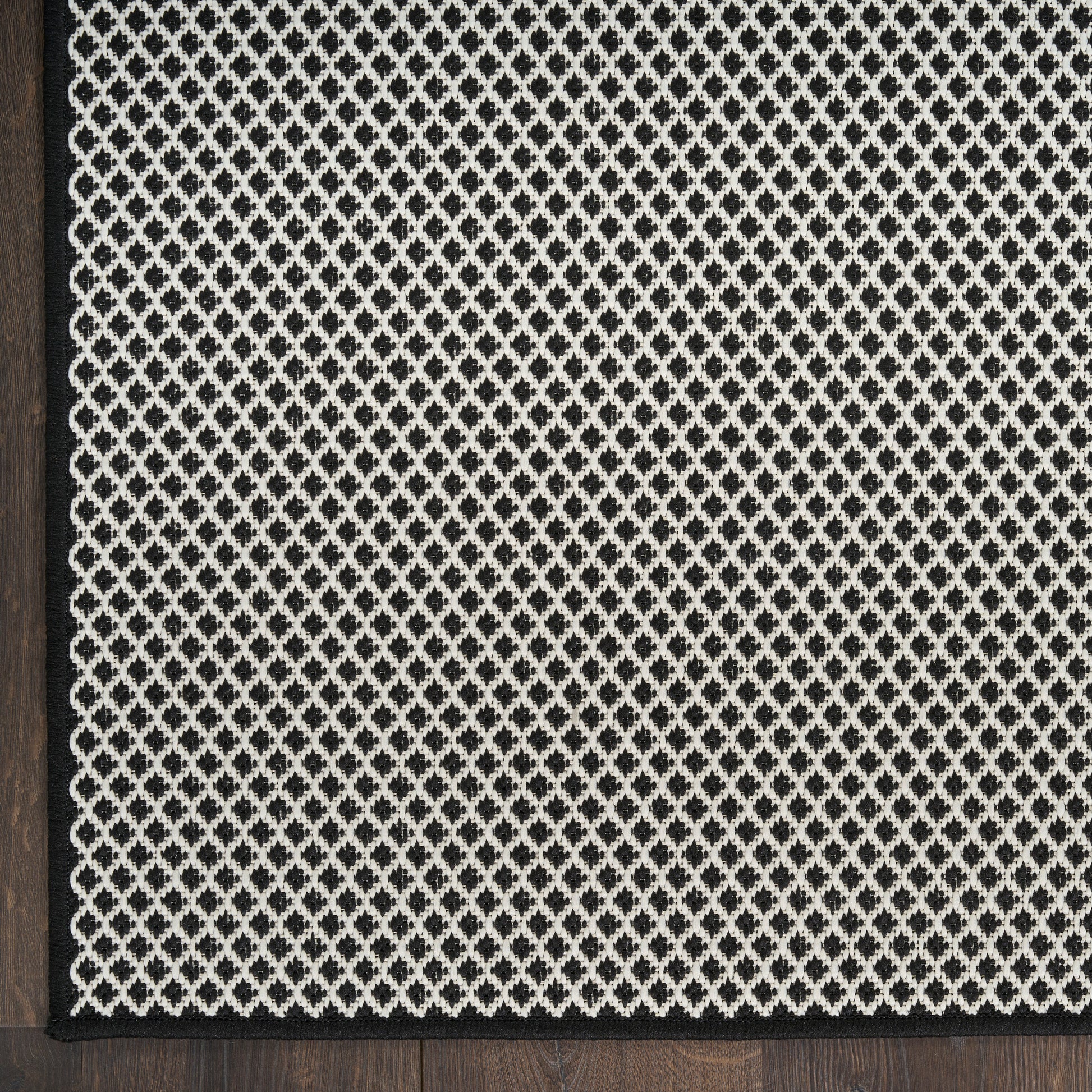 Black-framed decorative lattice panel featuring a white diamond mesh pattern on a dark textured background.