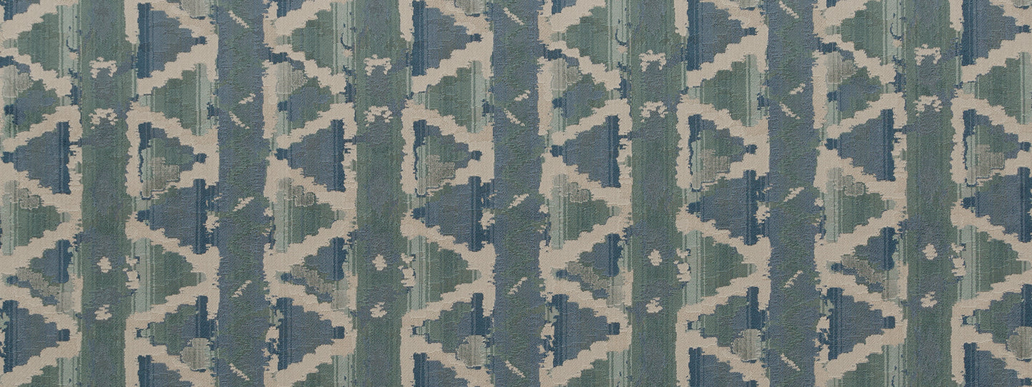 Teal and blue ikat-style geometric upholstery fabric with repeating triangles and diamonds on an off-white background.