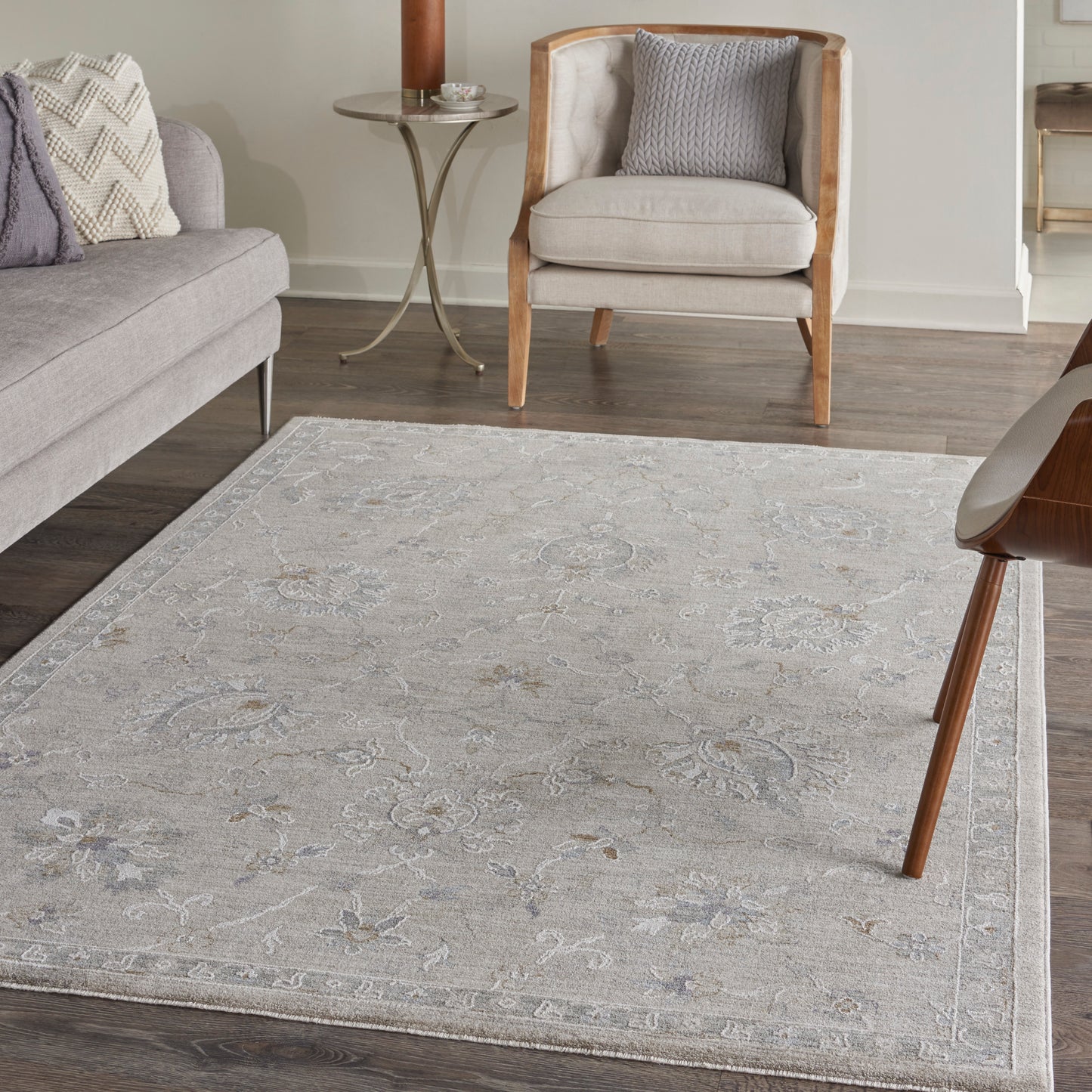 Neutral gray-beige woven area rug with delicate floral vine pattern and light border for contemporary living rooms.