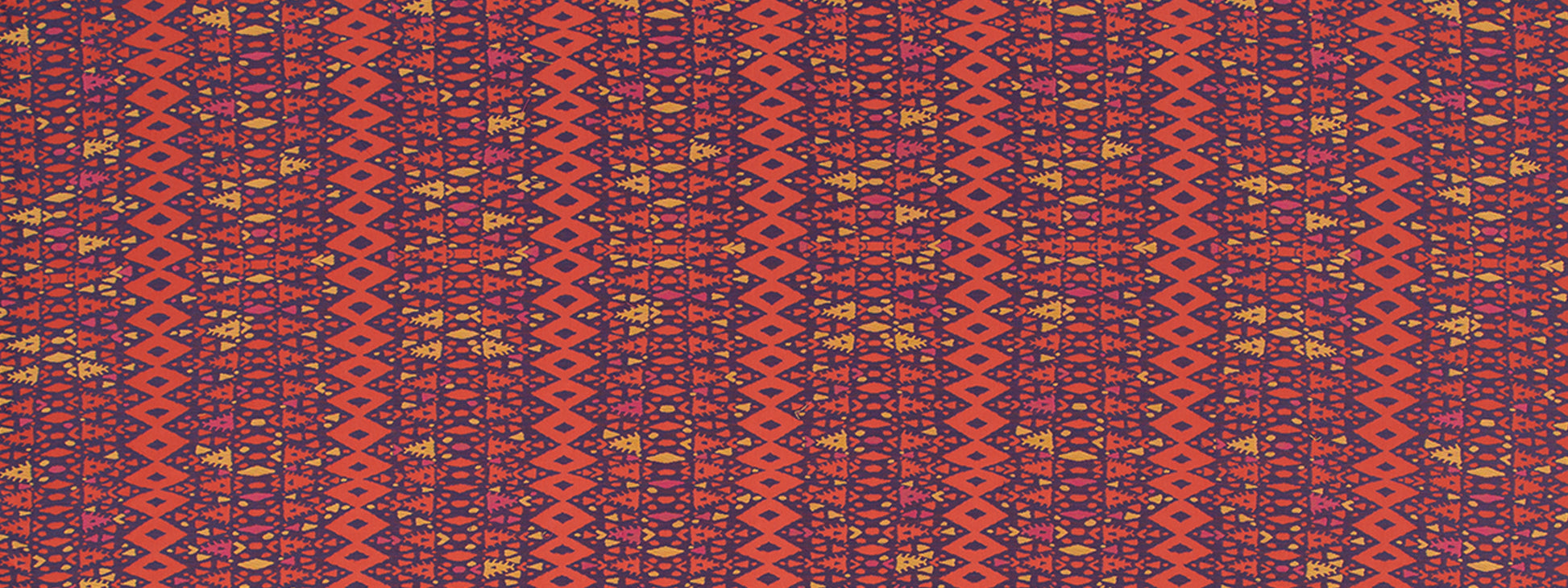 Close-up of orange-red woven textile with purple geometric diamonds and yellow accents in a kilim/tribal pattern.