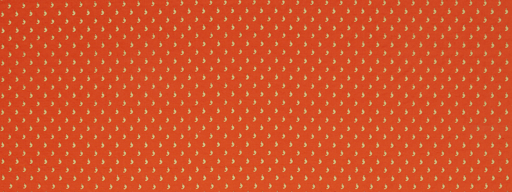 Orange-red fabric with tiny yellow leaf motifs in a dense repeating pattern; versatile textile for scarves or dresses.