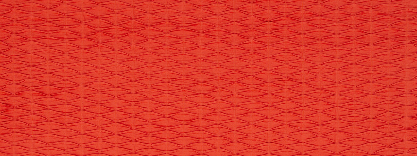 Red textured fabric with a small repeating diamond weave pattern; warm, vibrant upholstery material.